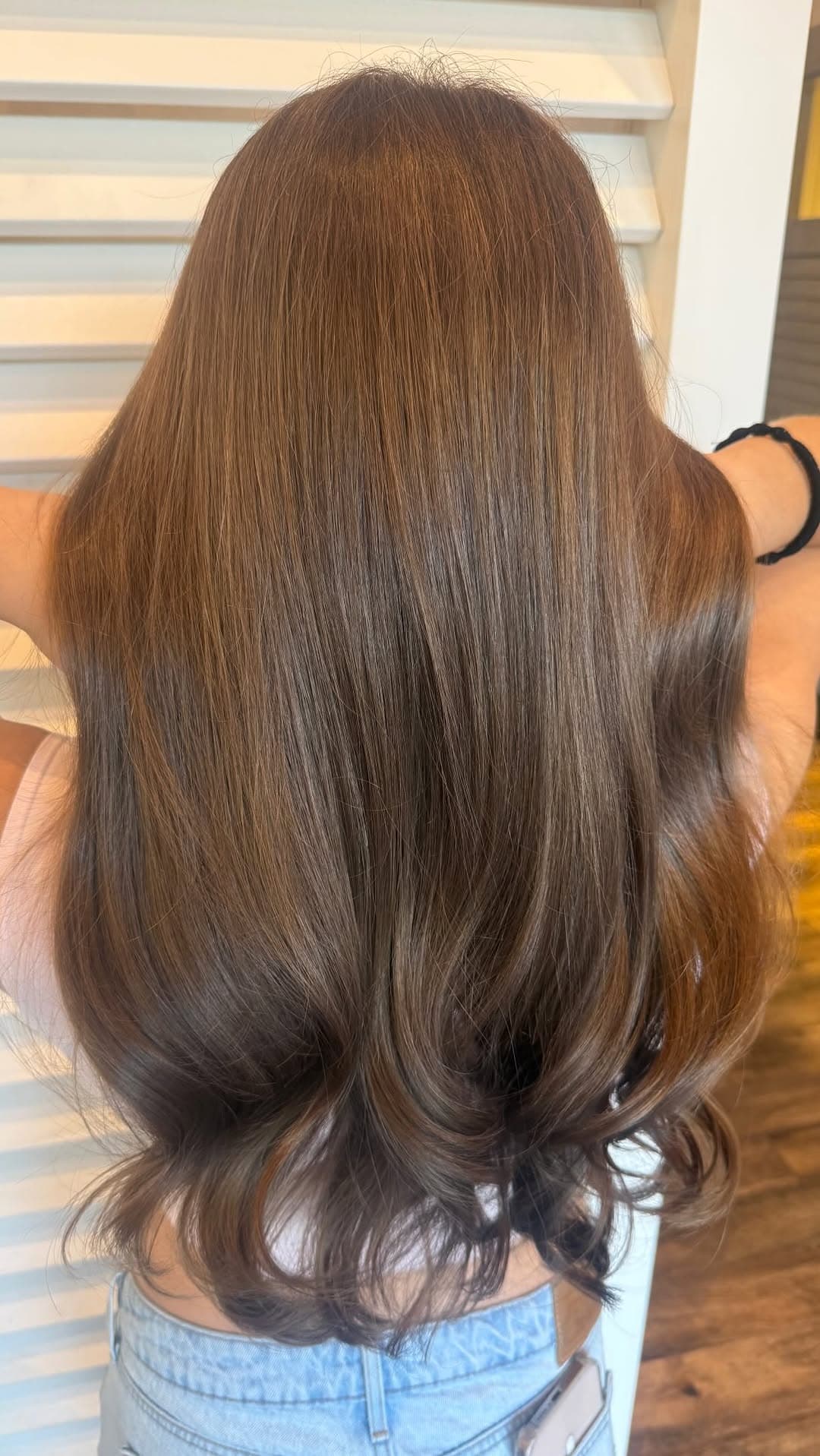 Long glossy brunette hair with soft curled ends by Courtney Morgan
